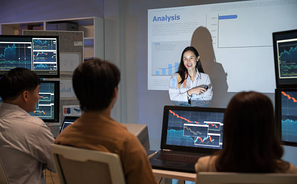 istock Asian business woman presentations slides chart graphs of work professionals collaborating on a late-night project meeting in a modern office. Brainstorming innovative ideas for a new business . 2217404559