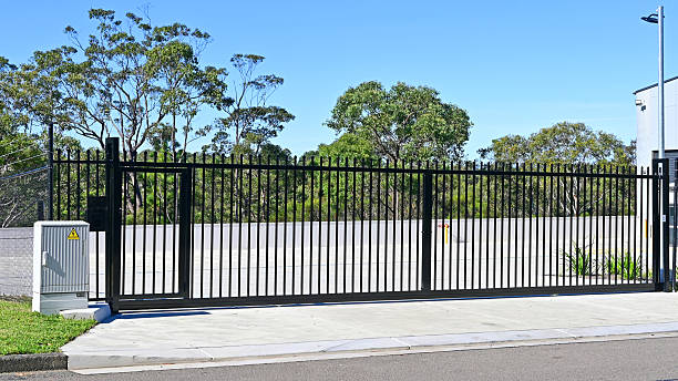 Automatic sliding metal gate Industrial style entrance gate to a factory site gate and fence stock pictures, royalty-free photos & images
