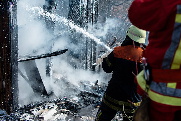 istock Firefighter put out a fire. Brave firefighter battling house fire blaze. Firemen in uniform in burning fire home. Firefighter uses hose to control fire. Firefighting concept. Firefighter in helmet on fire. 2217411127