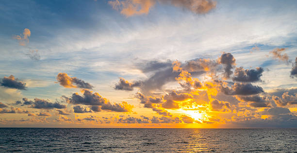 Sky at sunset. Sunrise over horizon. Sunlight shining through clouds on sky. Twilight sky with vibrant colors. Peaceful dawn with soft light. Dramatic dusk with glowing clouds. Sunshine in clear sky.