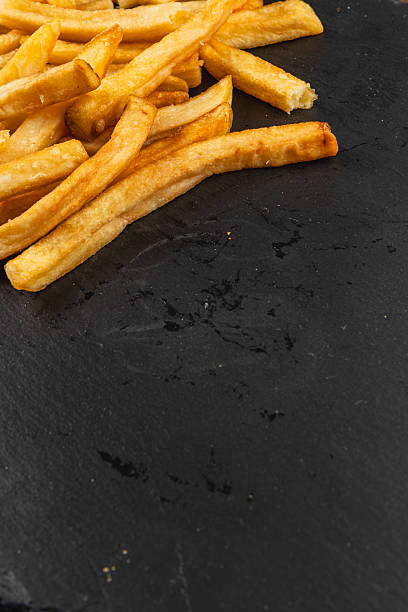 istock Crispy golden fries served on a dark slate plate 2217413822