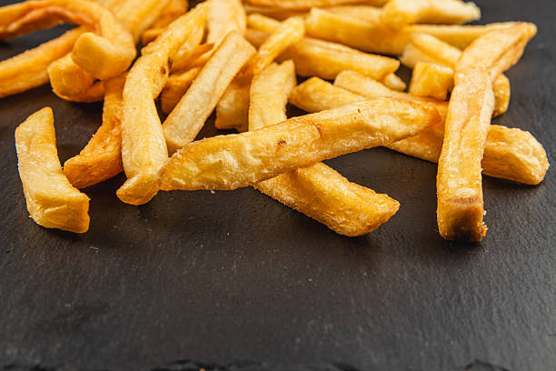istock Crispy golden fries served on a dark slate surface 2217414938