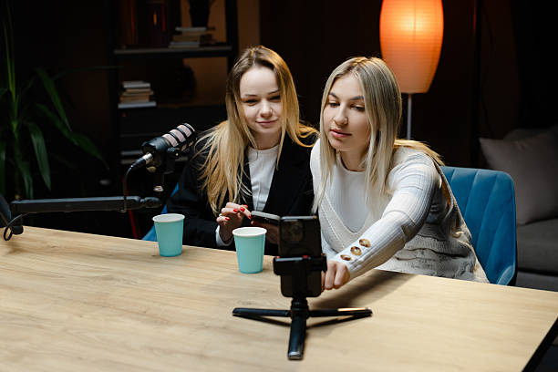 istock Two female podcasters recording video podcast using mobile phone 2217415123