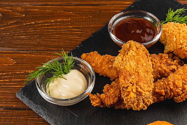 istock Crispy fried chicken served with sauces on a wooden table 2217417450