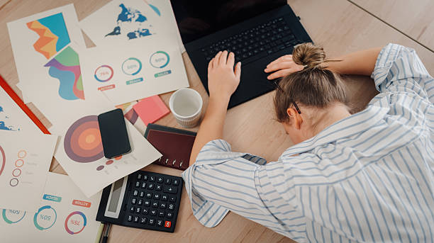 istock Exhausted businesswoman sleeping on laptop after working with charts and graphs 2217418607