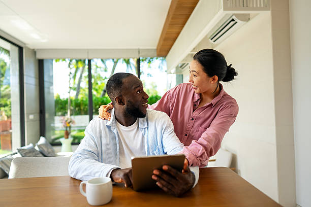istock Young happy multiethnic couple having fun while using tablet at home. Happy couple discussing future 2217419600