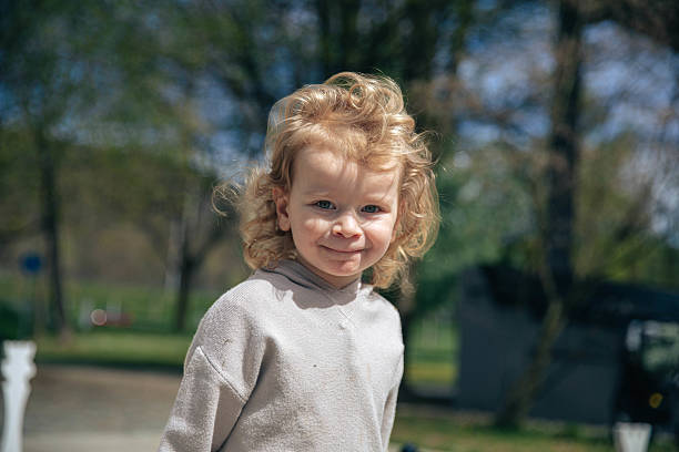 istock Caucasian young child smiling outdoors in a park on a sunny day 2217419626