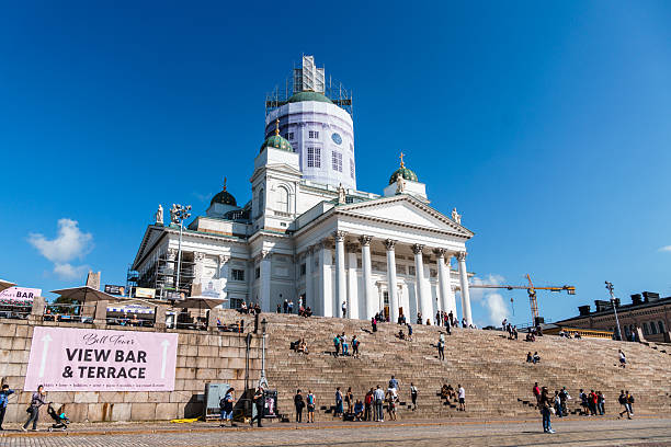Helsinki, Finland - 09 August 2022: Finnish Evangelical Lutheran cathedral and steps with relaxed people in Helsinki, Finland