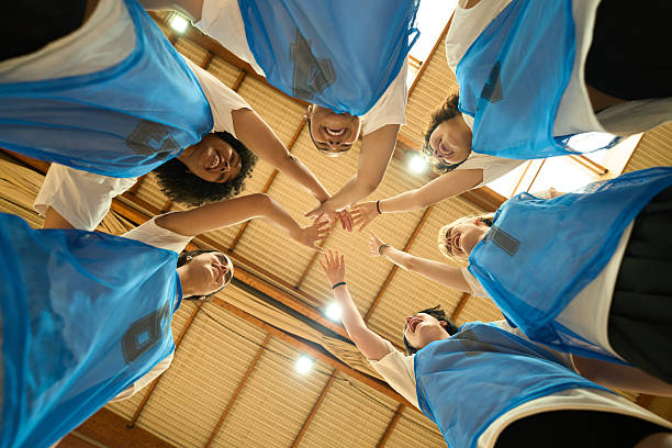 istock Female basketball team joining hands before game 2217423106