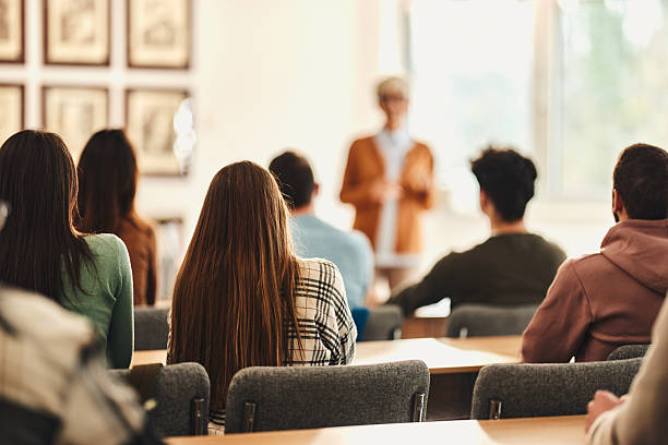 istock Back view of students attending a class in the classroom. 2217423487
