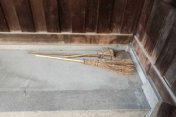 Small traditional brooms on a concrete floor.