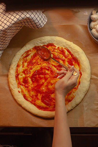 istock Making Homemade Pizza with Tomato Sauce 2217425430