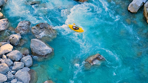 istock A kayaker navigates through a narrow, rocky river, showcasing thrilling whitewater kayaking 2217425770