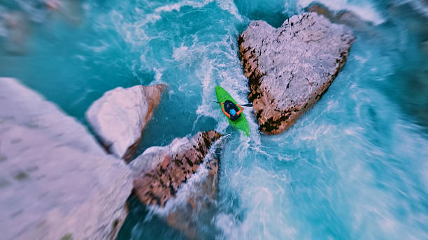 istock Kayaker conquers rapids, navigating through narrow, turbulent waters between jagged rocks 2217425777