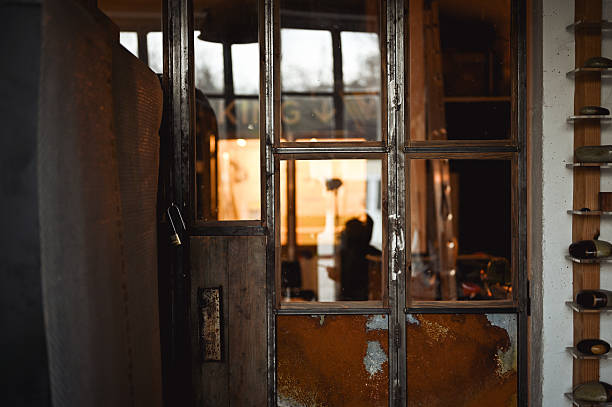 A girl's hand opens a door with bars in an abandoned prison, close-up photo.