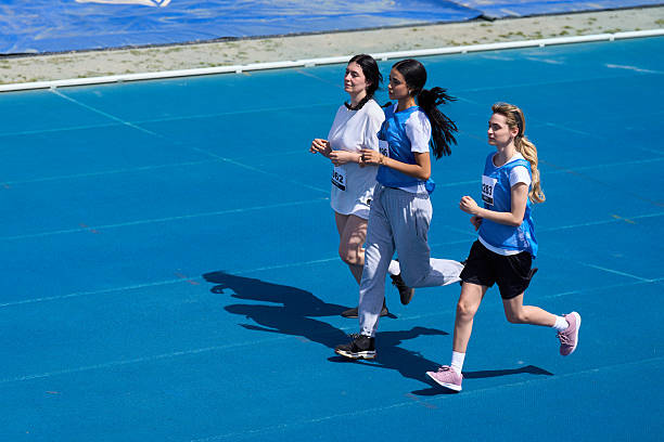istock Three teenagers running on a blue track 2217426982