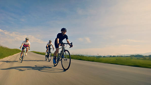 istock Three cyclists race down a scenic country road, showcasing their endurance and speed 2217427621
