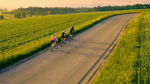 istock Three cyclists pedal through a scenic countryside, enjoying a group ride on a paved road 2217427633