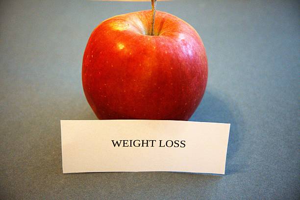 istock Weight loss subtitle or text with red apple and gray background. 2217427835