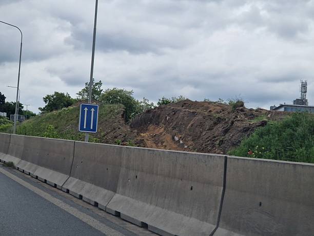 istock excavation for a pipe in the mountains. water transportation with state subsidies from development funds. protective wall near the railway station, work and movement of people are underway 2217429748