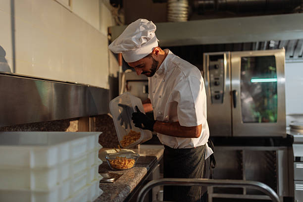 istock Chef pouring pasta in a bowl in a restaurant kitchen 2217431664