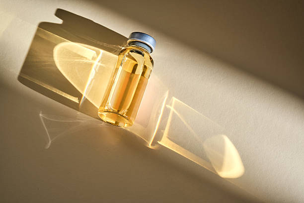 istock Injection vial with medicinal product in sunlight on beige background. 2217432724