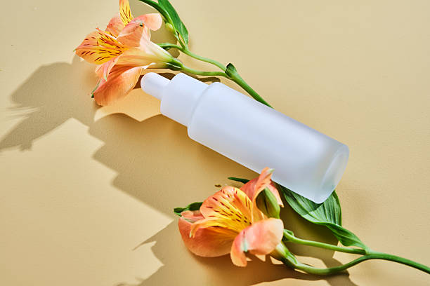 istock Regenerating serum with lifting effect on beige background with lilies. 2217433137