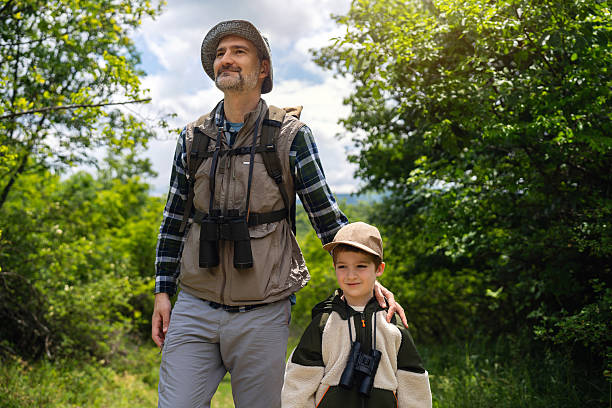 istock Father and son birdwatching together in a lush green forest setting 2217433869