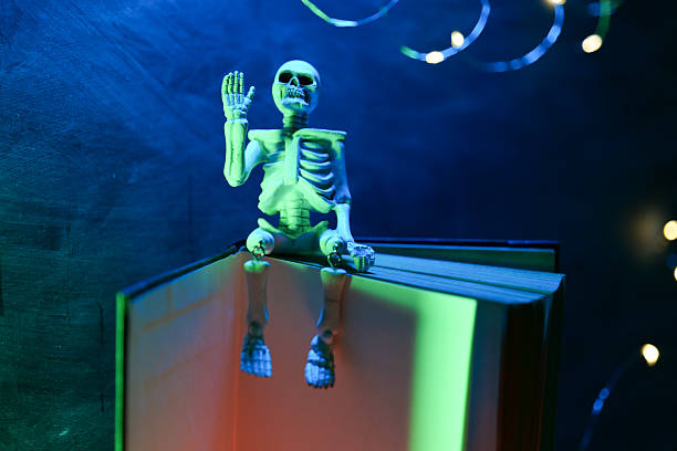 istock Book set, decorative skeleton on chalkboard background in ominous light.Spooky Stories for Halloween 2217434088