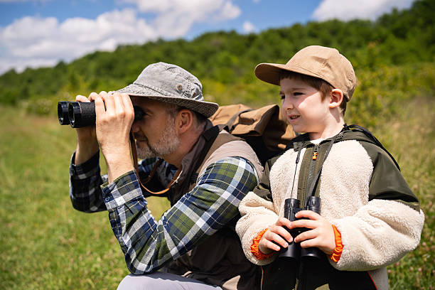 istock Father and son birdwatching together in the serene outdoors with binoculars 2217434449