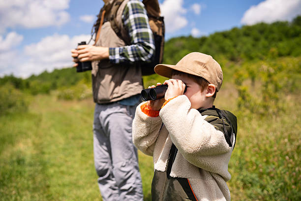 istock Father and son enjoying birdwatching together outdoors on a sunny day 2217434550