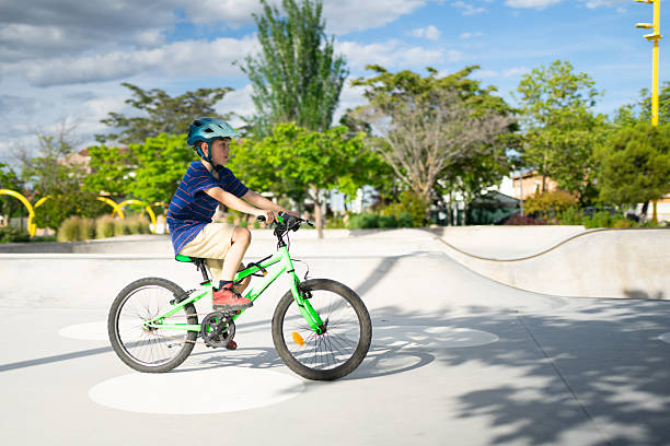 istock Young boy riding a bicycle in a skate park wearing a helmet 2217434791