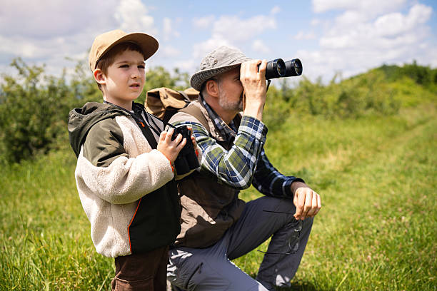 istock Father and son birdwatching in a grassy nature field 2217436116