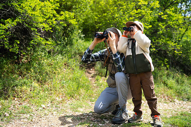 istock Father and son birdwatching together in a lush forest setting 2217437085