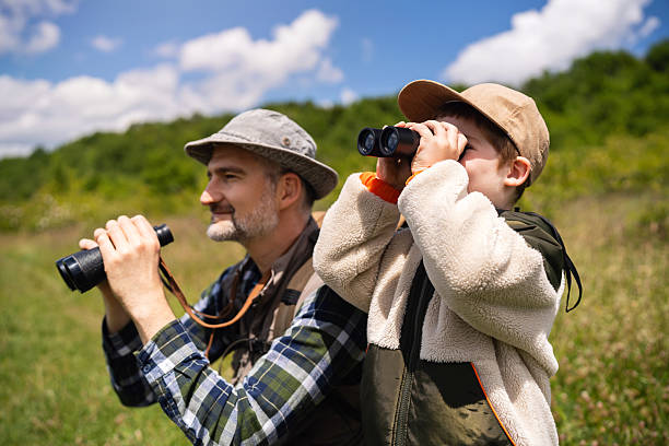 istock Father and son birdwatching together with binoculars in a lush outdoor setting 2217437346