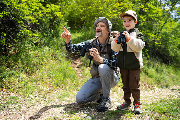 istock Father and son enjoying birdwatching in a lush green forest 2217437476