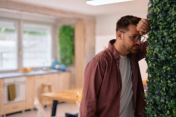 istock Stressed man leaning against a wall with his head in his hand 2217440306