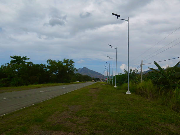 istock View of a flat road, roadside and lamp posts. 2217440360