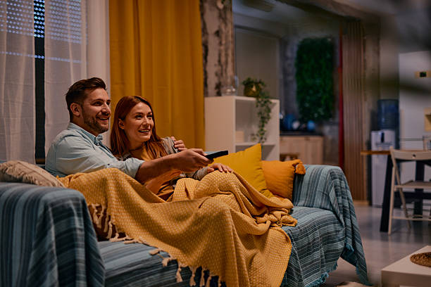 istock Couple relaxing on sofa watching television at night 2217440523
