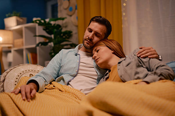 istock Serene couple sleeping on sofa, embracing tenderness and tranquility at home 2217440605