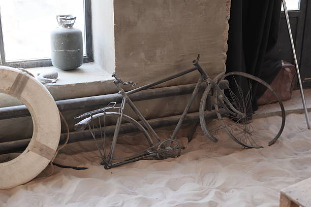 A vintage bicycle rests in a sandy, modern space, blending nostalgia with contemporary design elements