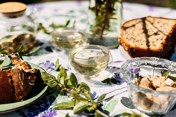 istock A pleasant table setup outdoors featuring a plate of bread, nuts in jars, and greenery in a vase. Perfect for themes of rustic living, garden parties, and food-related branding 2217447146