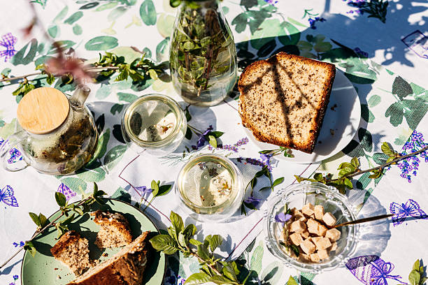 istock A pleasant table setup outdoors featuring a plate of bread, nuts in jars, and greenery in a vase. Perfect for themes of rustic living, garden parties, and food-related branding 2217447148