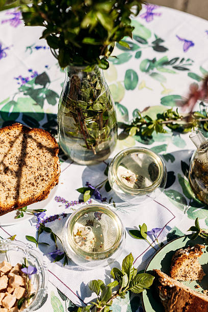 istock A pleasant table setup outdoors featuring a plate of bread, nuts in jars, and greenery in a vase. Perfect for themes of rustic living, garden parties, and food-related branding 2217447154