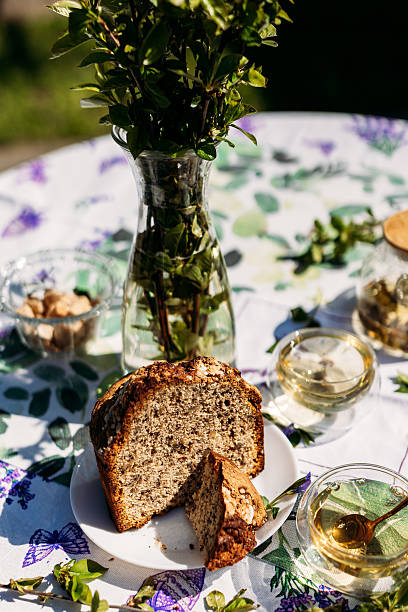 istock A rustic outdoor table setting featuring a homemade slice of bread on a green plate, surrounded by greenery and glass jars. Perfect for food photography, lifestyle branding, and rustic themes. 2217447163