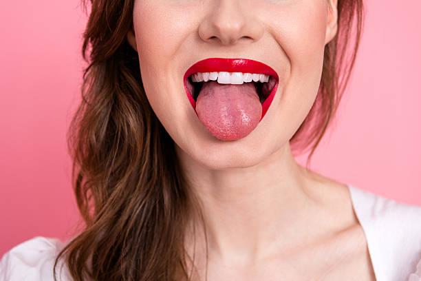 istock Charming young woman with bright lipstick showing playful expression on pink background emphasizing beauty and style 2217448407
