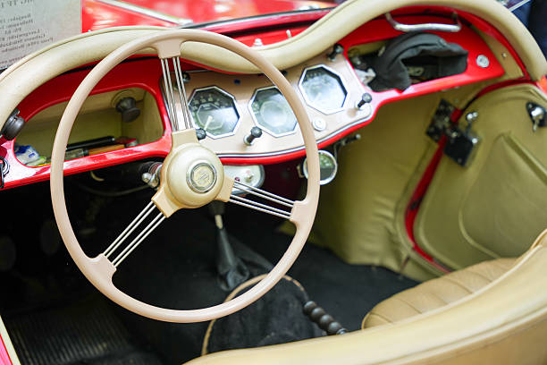 Germany Berlin May 11, 2025. MG Vintage Car Interior Red-Beige. The interior of a vintage MG car features a classic steering wheel and a red-beige cockpit with loving details. The stylish instruments convey a pure 1950s driving experience.