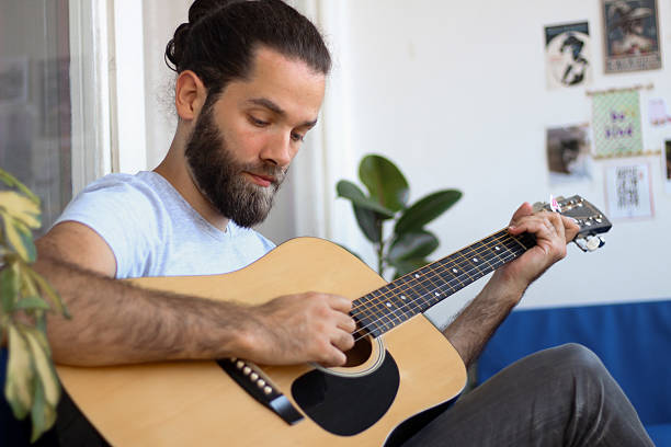 istock Young man playing acoustic guitar 2217451348