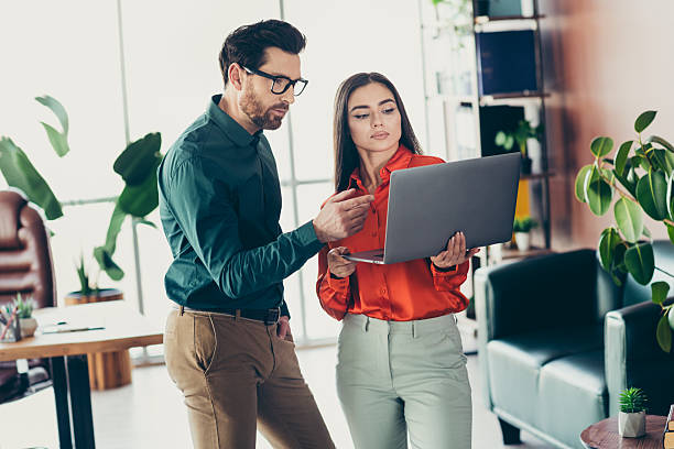 istock Professional colleagues discussing a project on a laptop in a modern office environment. 2217451643