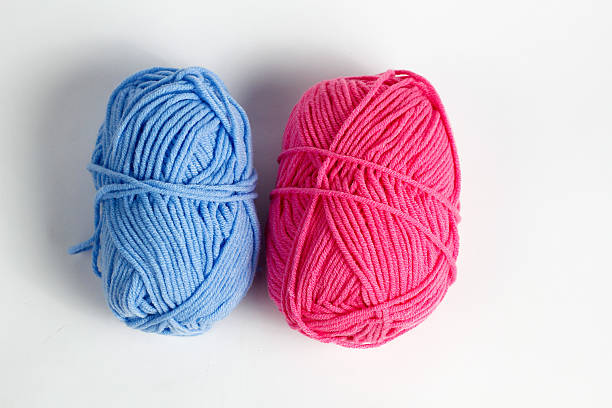 istock Pink and blue wool thread neatly rolled into an oval shape isolated on a white background 2217455182